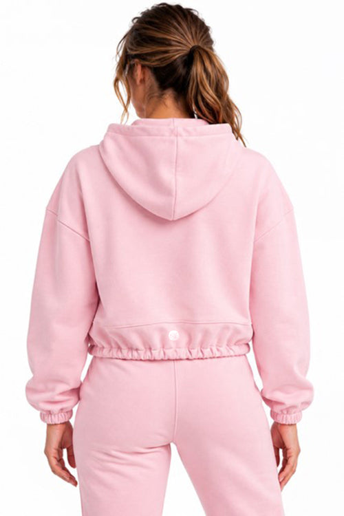 Pink cropped oversized hoodie worn by a model, back view against a white background